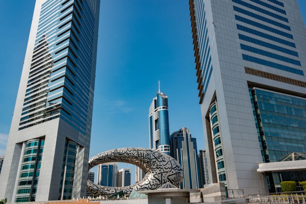 Discover the futuristic architecture amidst Dubai's towering cityscape under a clear blue sky.