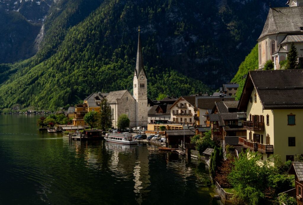 Charming view of Hallstatt with its iconic church by the lake against a backdrop of mountains.